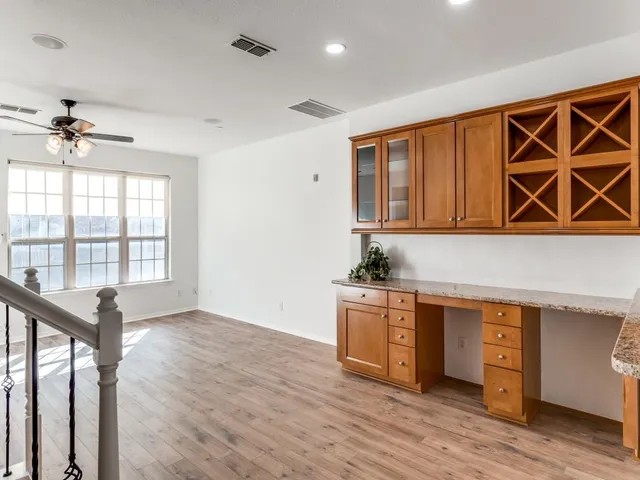 a view of a livingroom with wooden floor and a ceiling fan