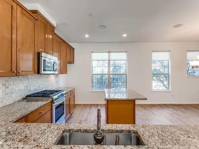 a view of a room with wooden floor chandelier and windows