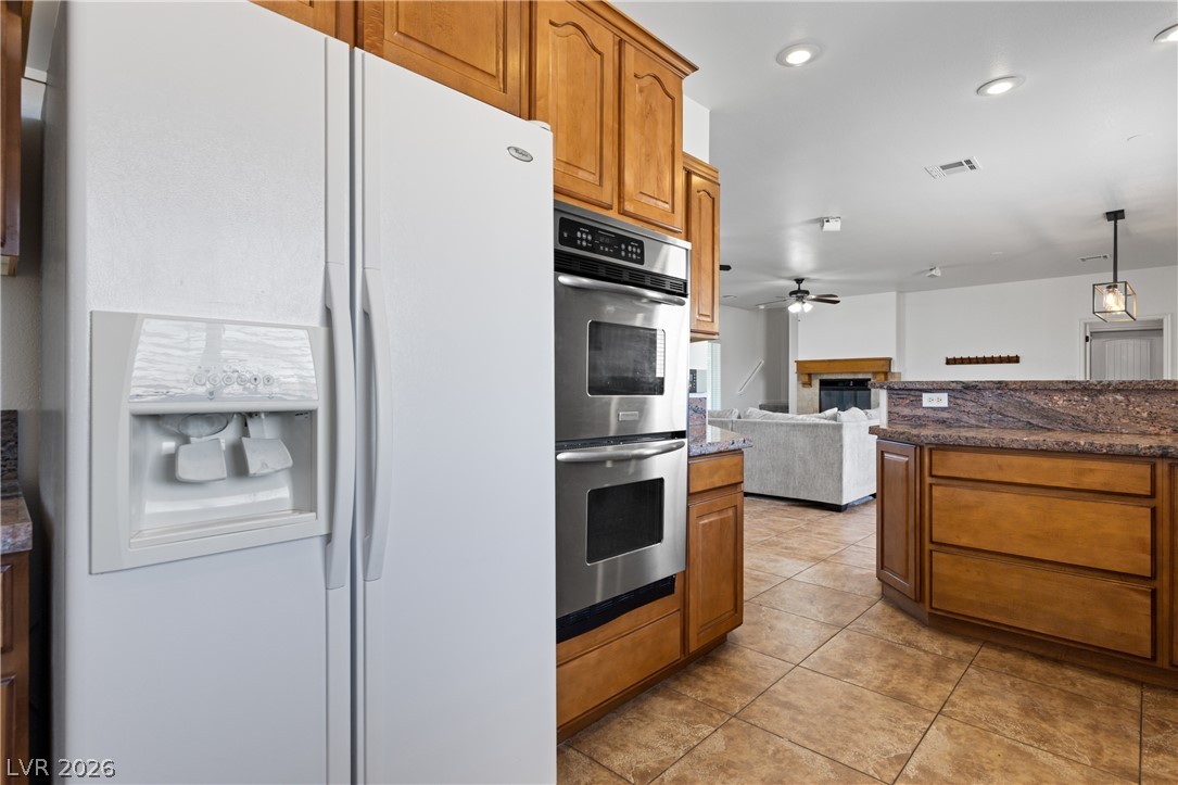 575 Gann Avenue Logandale, NV 89021 - Photo 21 of 75 A well-appointed kitchen features warm wood cabinetry, granite countertops, and modern stainless steel appliances.