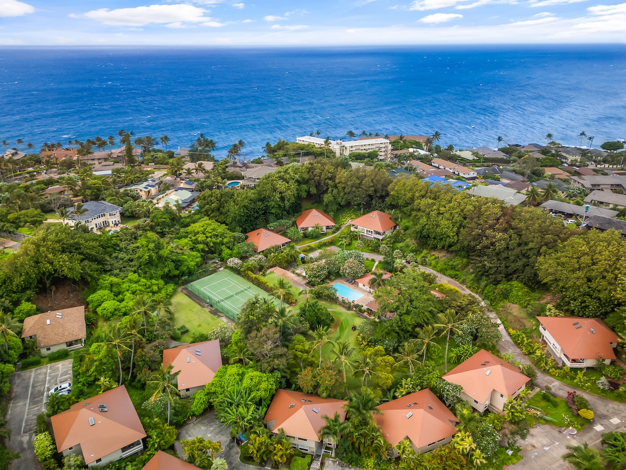 an aerial view of ocean and residential houses with outdoor space