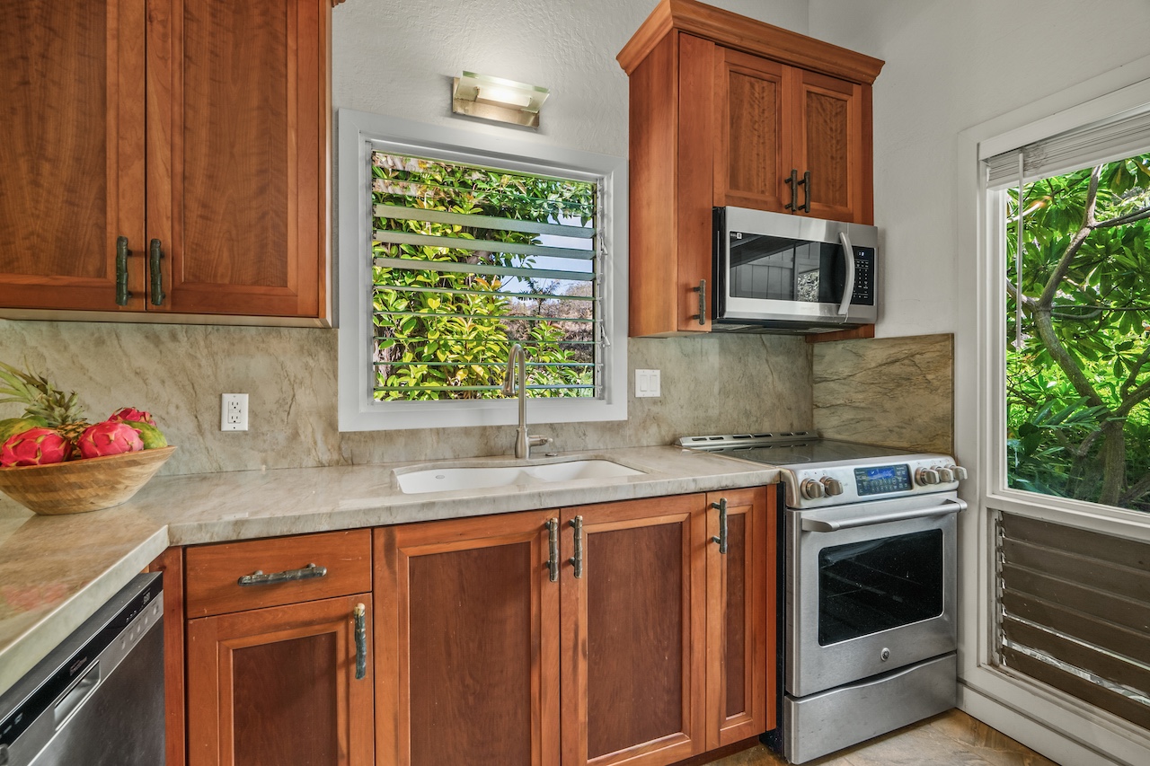 2330 Ho'ohu Road, Unit 5 Koloa, HI 96756 - Photo 5 of 28 a kitchen with granite countertop a stove top oven microwave and cabinets
