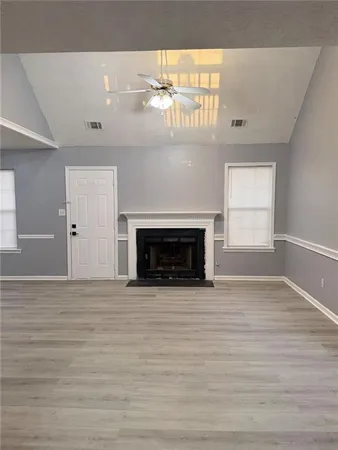a view of an empty room with a fireplace and a window