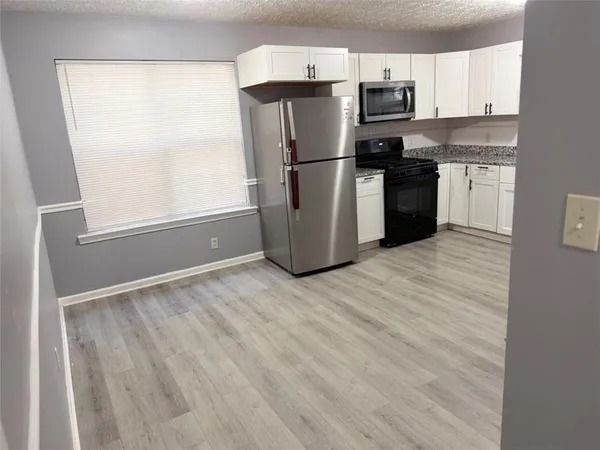 a kitchen with a refrigerator and a stove top oven
