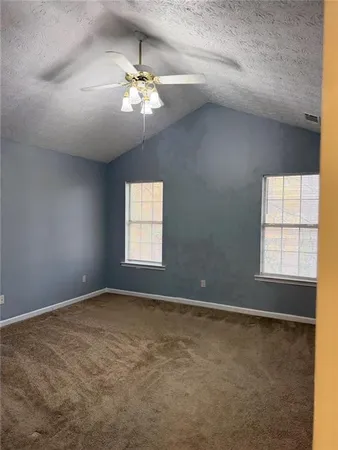 en empty room with windows and chandelier fan