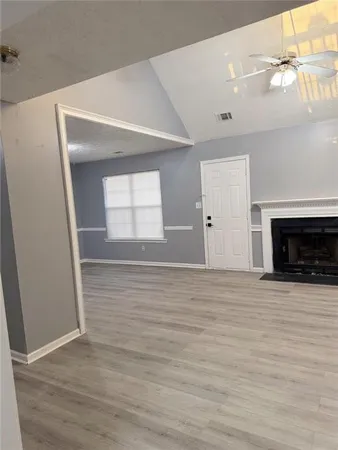 a view of empty room with wooden floor and fireplace
