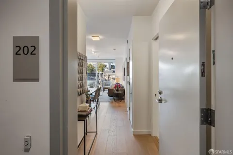 a view of a hallway with wooden floor windows and a livingroom