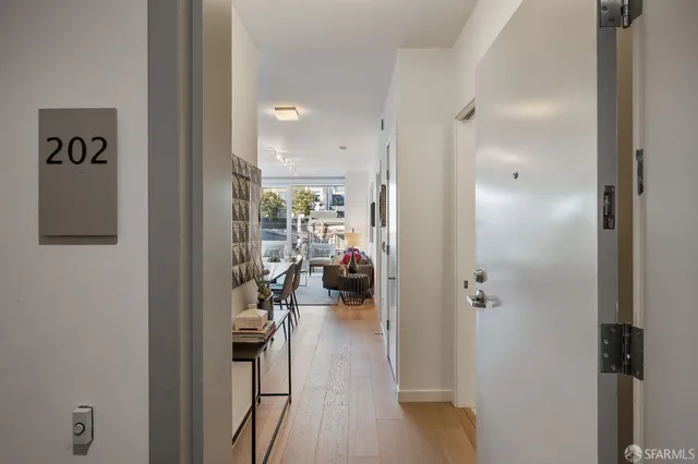 a view of a hallway with wooden floor windows and a livingroom