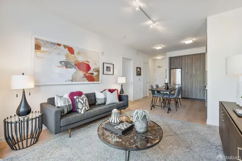 a living room with furniture and a dining table with rug