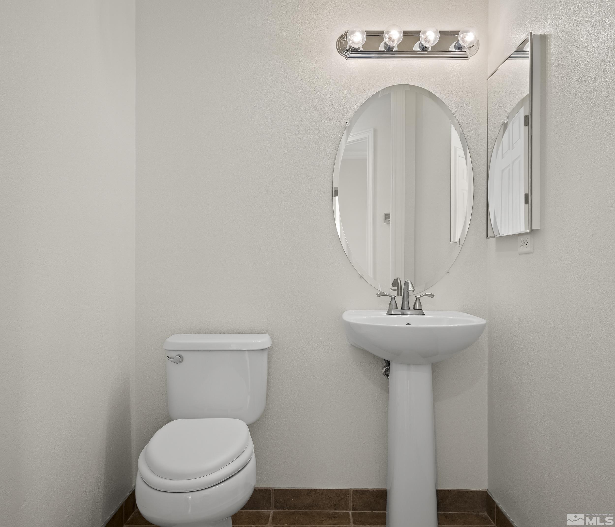 1575 Wyatt Court Reno, NV 89521 - Photo 23 of 40 a bathroom with a toilet a sink and mirror