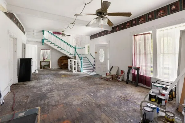 a view of a bedroom with wooden floor and windows