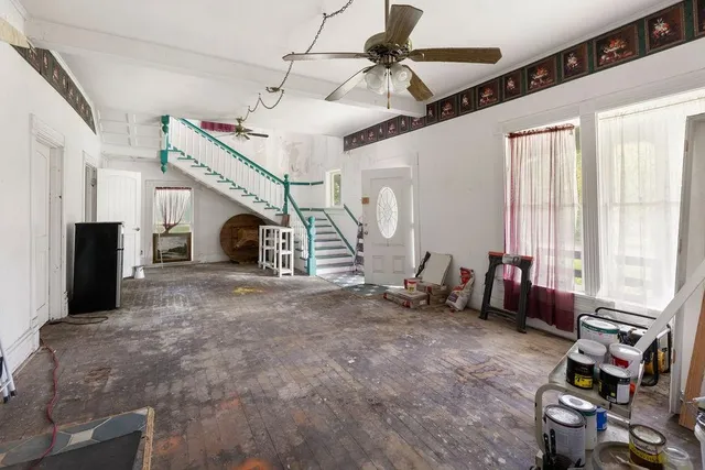 a view of a bedroom with wooden floor and windows