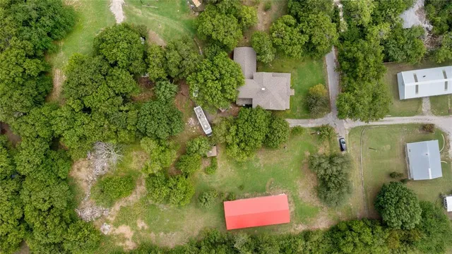 an aerial view of residential house with outdoor space and trees all around