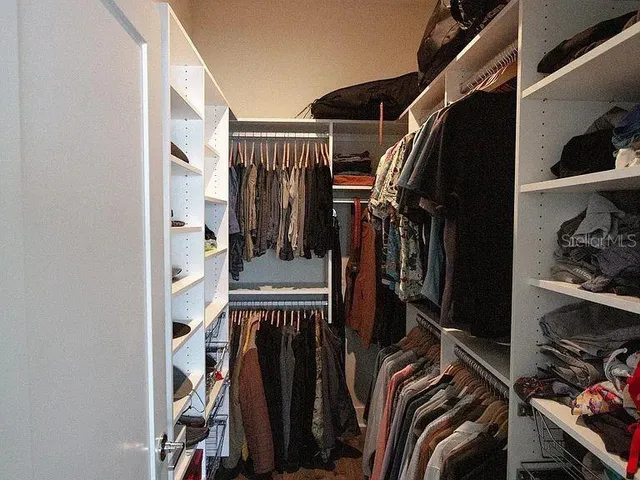 a view of walk in closet with clothes and shoes