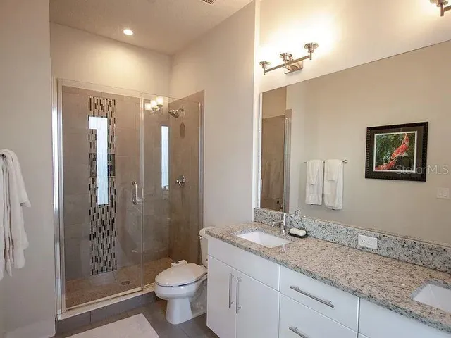 a bathroom with a granite countertop sink toilet and shower