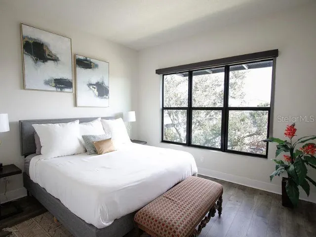 a bedroom with a bed and a large window