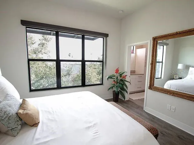 a bedroom with a bed and a large window