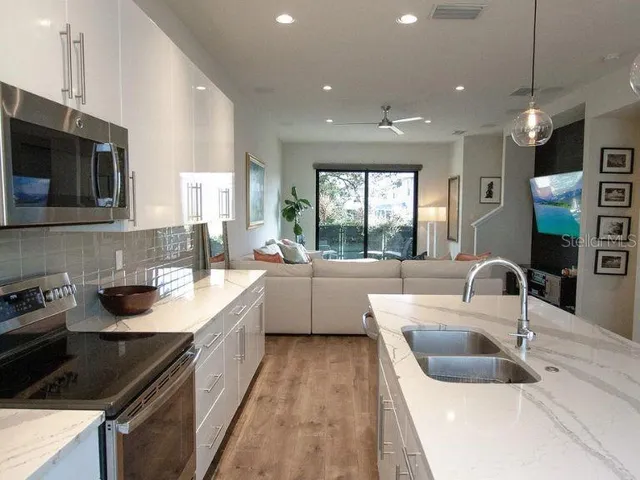 a kitchen with a sink stove top oven and microwave