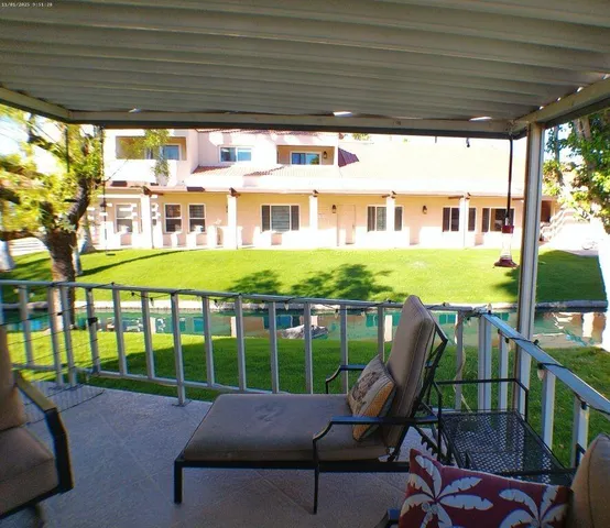 a view of a porch with furniture and a yard