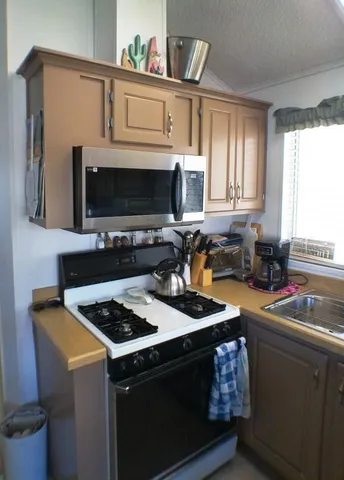 a kitchen with stainless steel appliances a sink a stove and a microwave