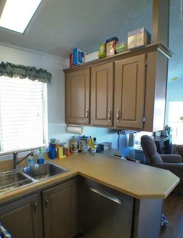 a kitchen with stainless steel appliances granite countertop a kitchen island a stove a dining table and chairs with wooden floor