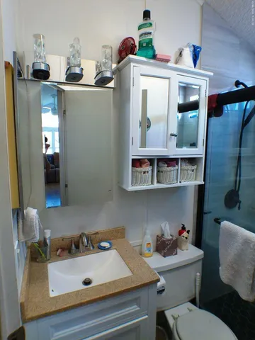 a view of a refrigerator in kitchen and an empty room