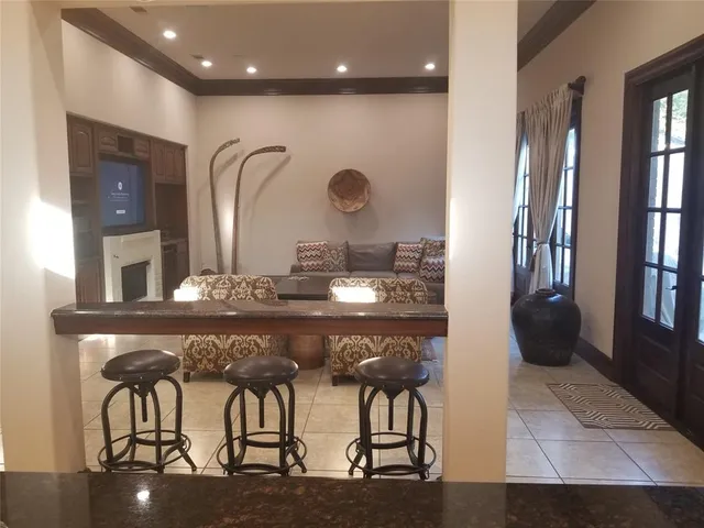 a room with stainless steel appliances kitchen island granite countertop furniture and a view of kitchen