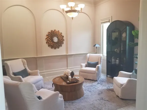 a hallway with a chandelier and a dining table