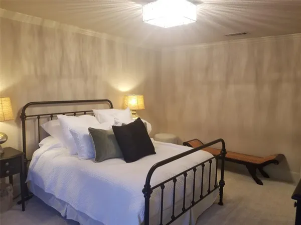 a bedroom with a bed and a lamp with the table