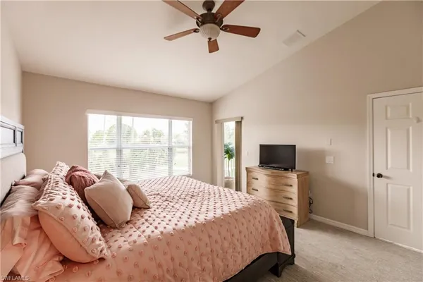 a bedroom with a bed flat screen tv and a window