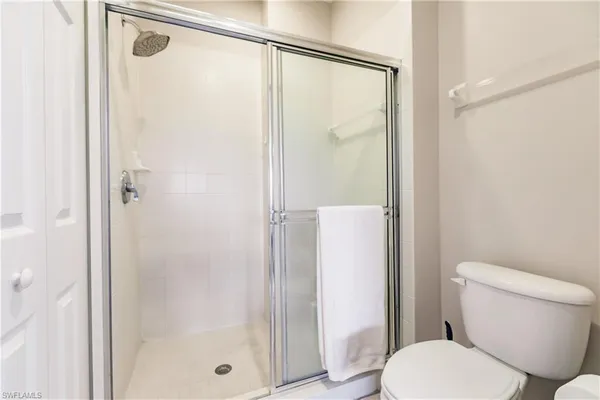 a white toilet sitting next to a bathroom shower
