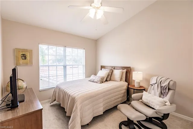 a bedroom with a bed a large window and flat screen tv