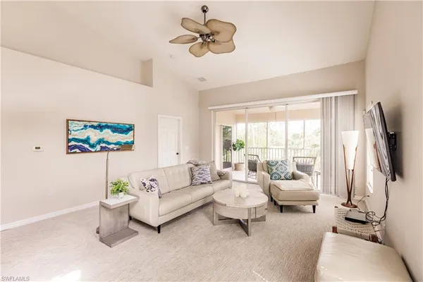 a living room with furniture a flat screen tv and a large window