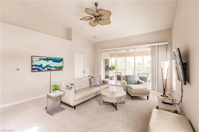 a living room with furniture a flat screen tv and a large window