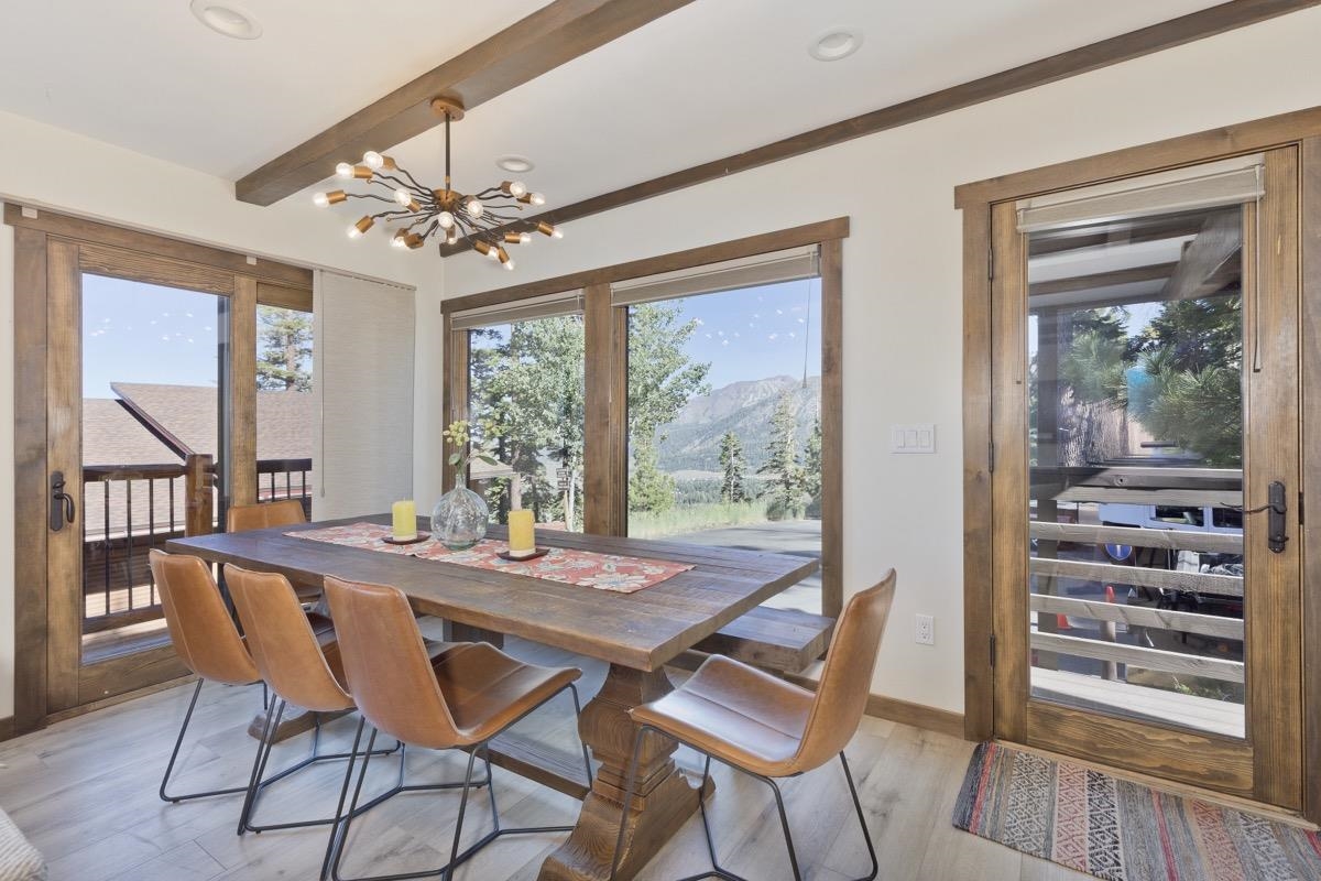 670 John Muir Road, Unit 1 Mammoth Lakes, CA 93546 - Photo 9 of 50 Dining room with light wood-style flooring, a chandelier, and beamed ceiling