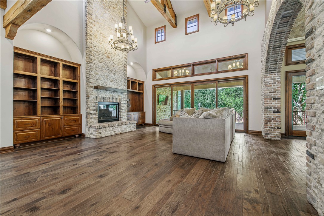 4207 Tuscany Court Bryan, TX 77802 - Photo 12 of 50 Living room featuring beamed ceiling, dark wood-style floors, a chandelier, a fireplace, and plenty of natural light