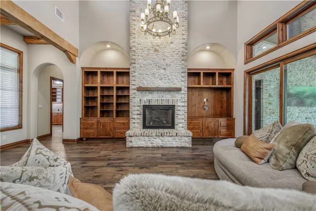 a living room with furniture a fireplace and a large window