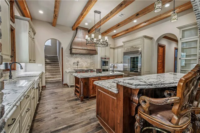 a kitchen with stainless steel appliances granite countertop a stove a sink dishwasher and cabinets with wooden floor