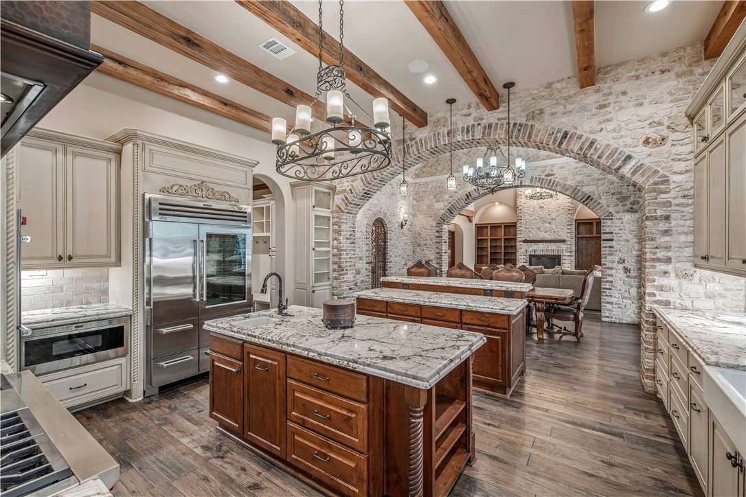 4207 Tuscany Court Bryan, TX 77802 - Photo 22 of 50 Kitchen featuring cream cabinets, light stone countertops, a chandelier, stainless steel built in refrigerator, and hanging light fixtures