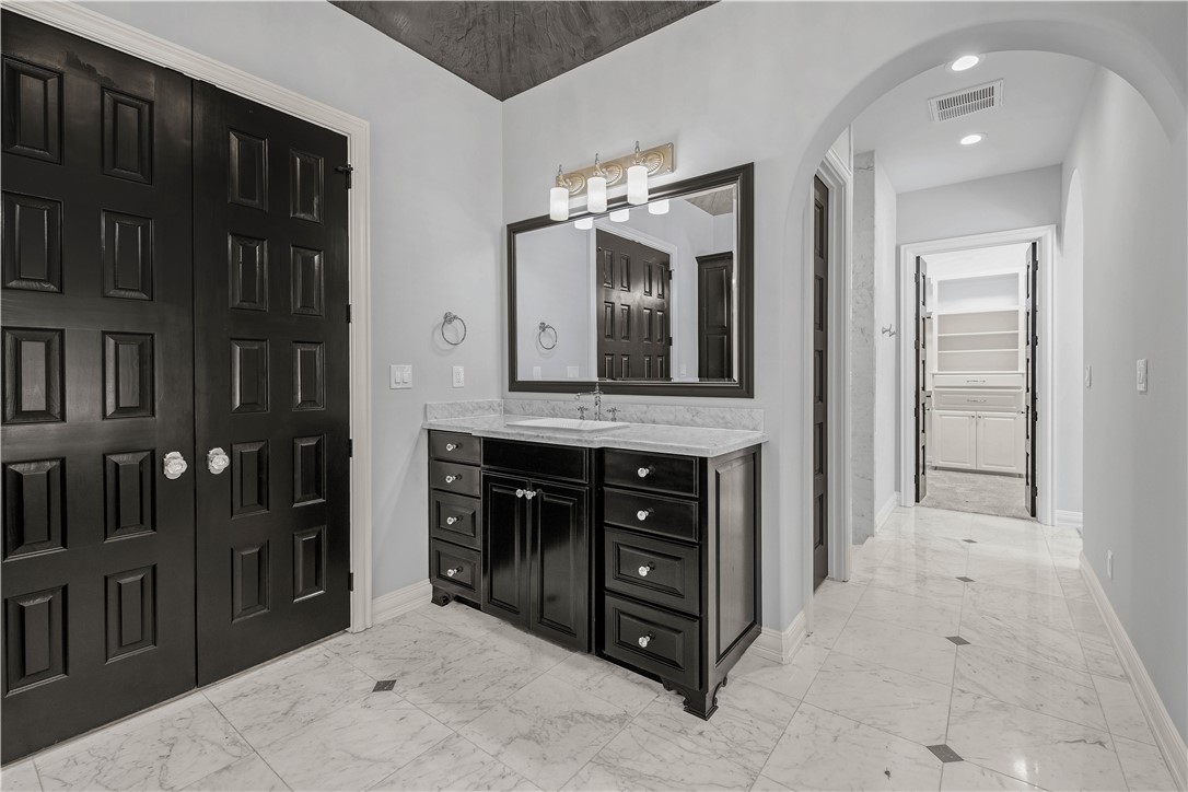 4207 Tuscany Court Bryan, TX 77802 - Photo 25 of 50 Bathroom featuring light marble finish flooring, vanity, and a walk in closet