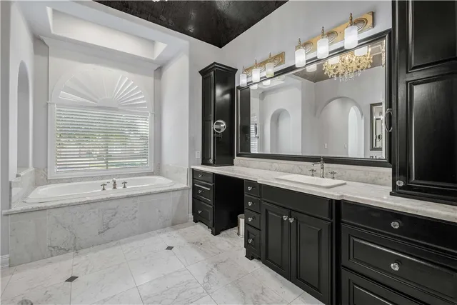 a bathroom with a double vanity sink mirror and bathtub