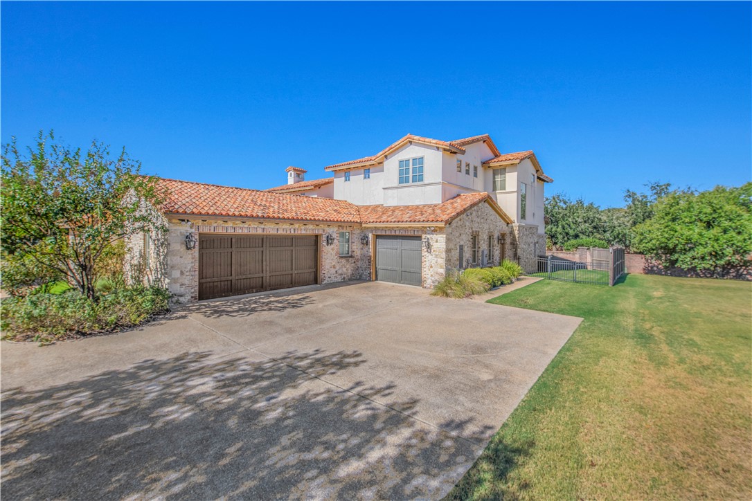 4207 Tuscany Court Bryan, TX 77802 - Photo 3 of 50 Mediterranean / spanish house featuring a tile roof, stucco siding, driveway, stone siding, and a gate