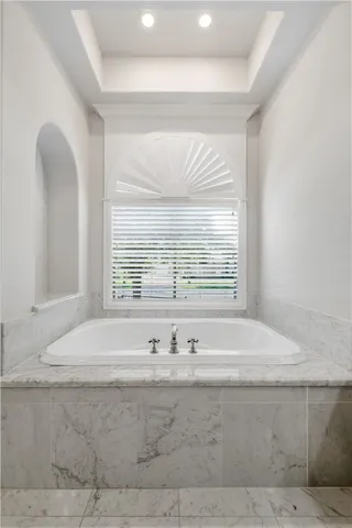 a bathroom with bathtub and window