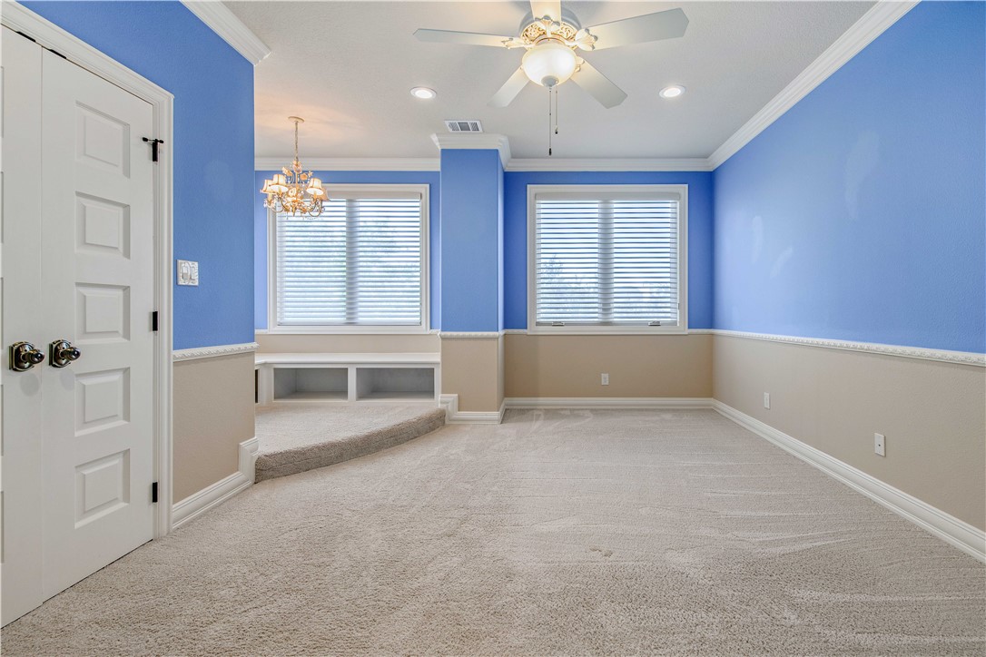 4207 Tuscany Court Bryan, TX 77802 - Photo 35 of 50 Empty room with light carpet, crown molding, a chandelier, a ceiling fan, and recessed lighting
