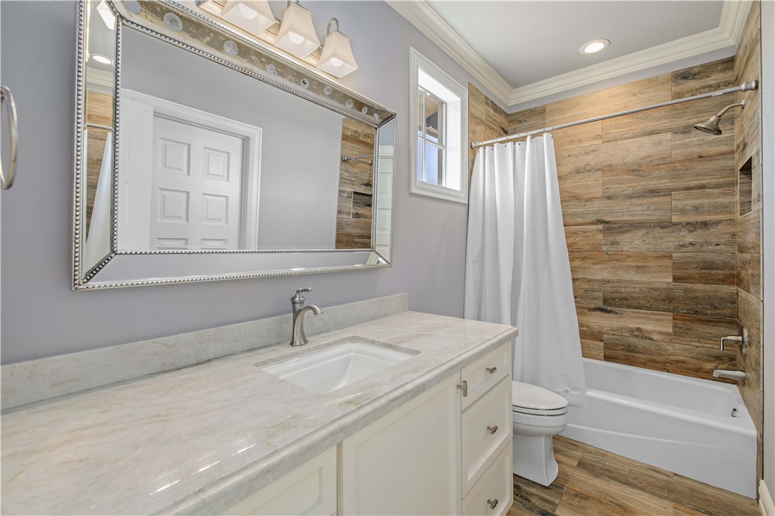 4207 Tuscany Court Bryan, TX 77802 - Photo 41 of 50 Bathroom featuring dark wood-style flooring, shower / tub combo with curtain, vanity, and crown molding