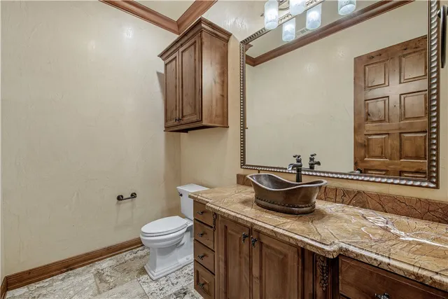 a bathroom with a granite countertop sink a toilet and a mirror