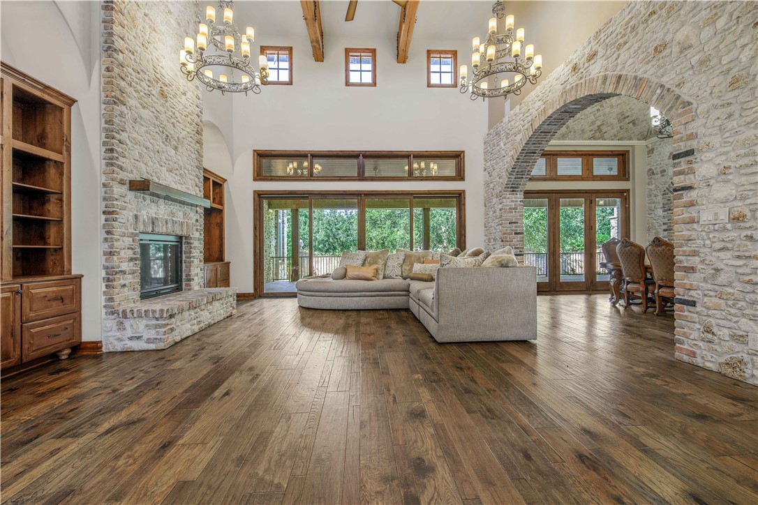 4207 Tuscany Court Bryan, TX 77802 - Photo 10 of 50 Living area with dark wood finished floors, beamed ceiling, french doors, a fireplace, and a high ceiling