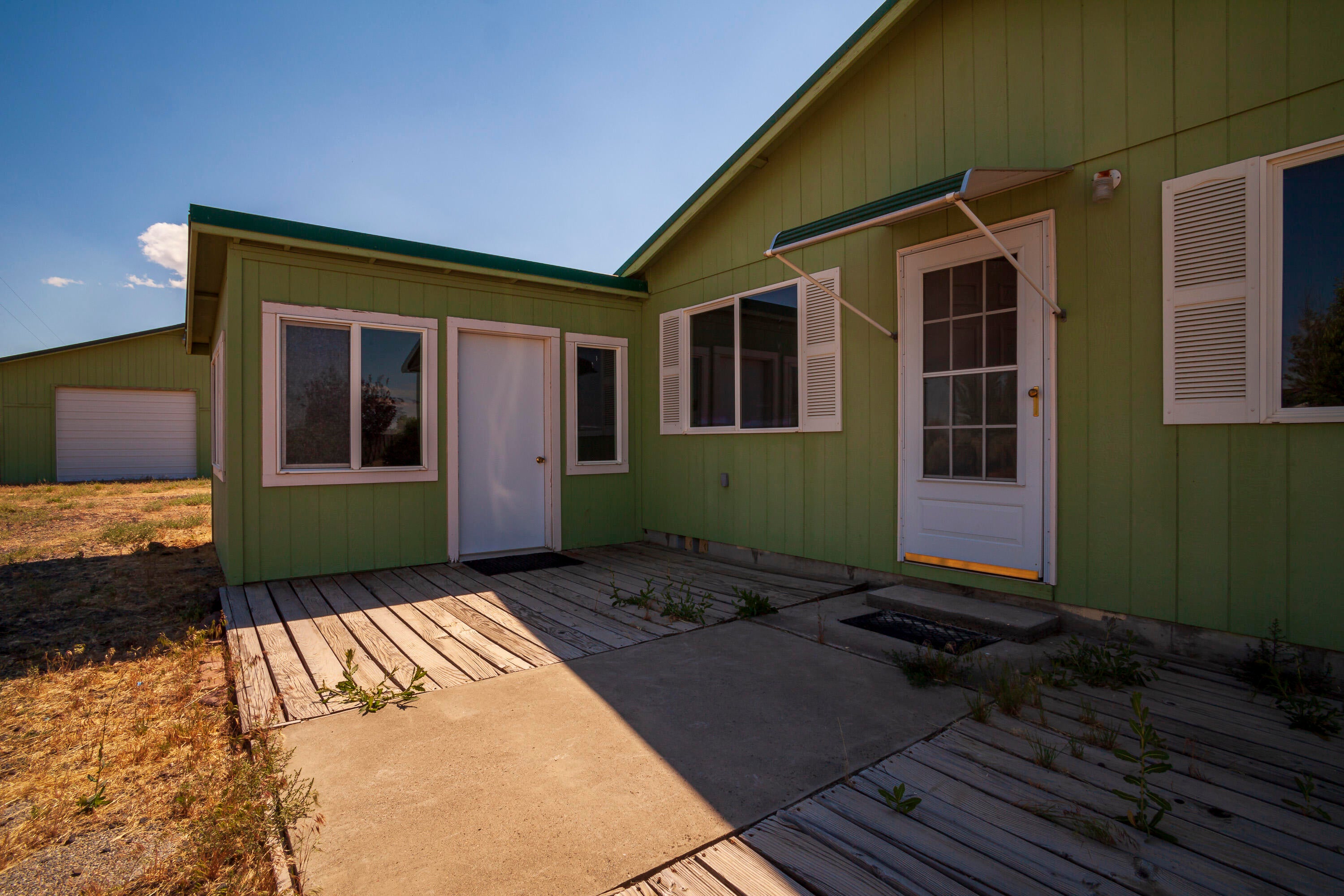 57282 Tinsel Road Christmas Valley, OR 97641 - Photo 22 of 54 Front deck with Sunroom door (center) and main home door (@ right). At the far left is the shop beyond.