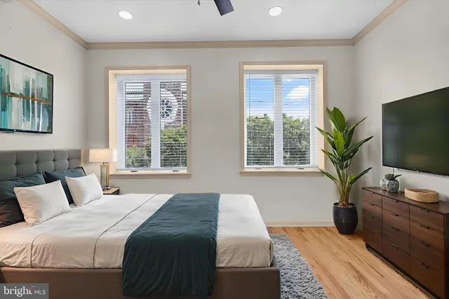 a bedroom with a large bed and a flat tv screen on dresser