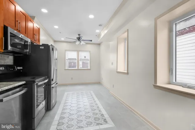 a kitchen with stainless steel appliances granite countertop a refrigerator a oven a sink dishwasher and a refrigerator with wooden floor