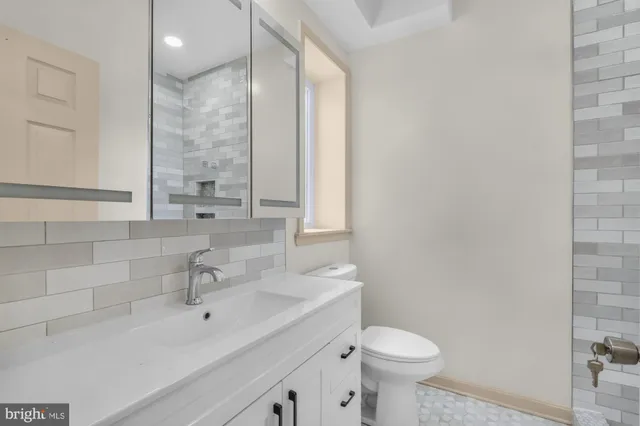 a bathroom with a sink a toilet and a mirror